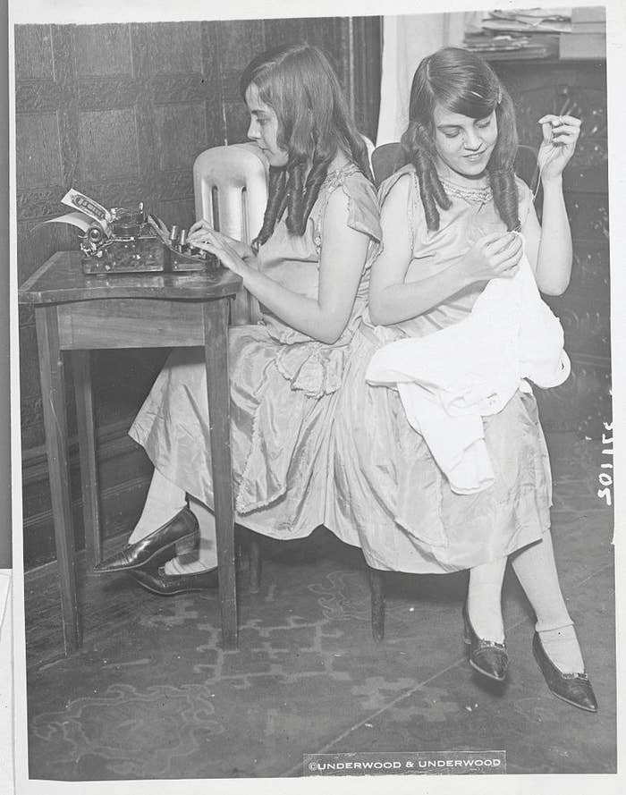 image of Daisy and Violet Hilton typing and sewing.
