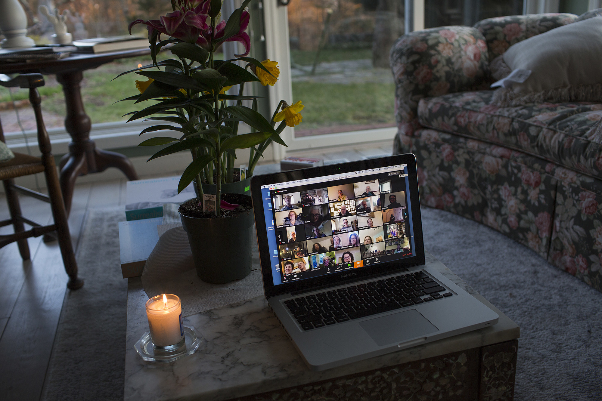 A laptop shows a populated Zoom window