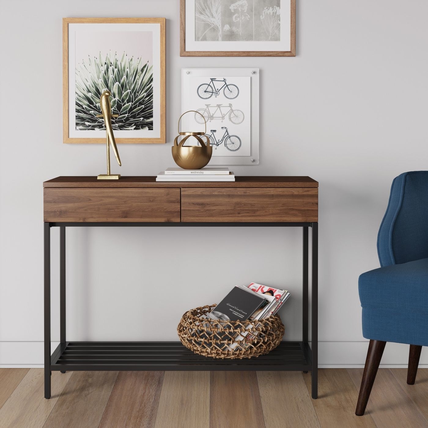 walnut and metal console table against a wall with books and decor on top