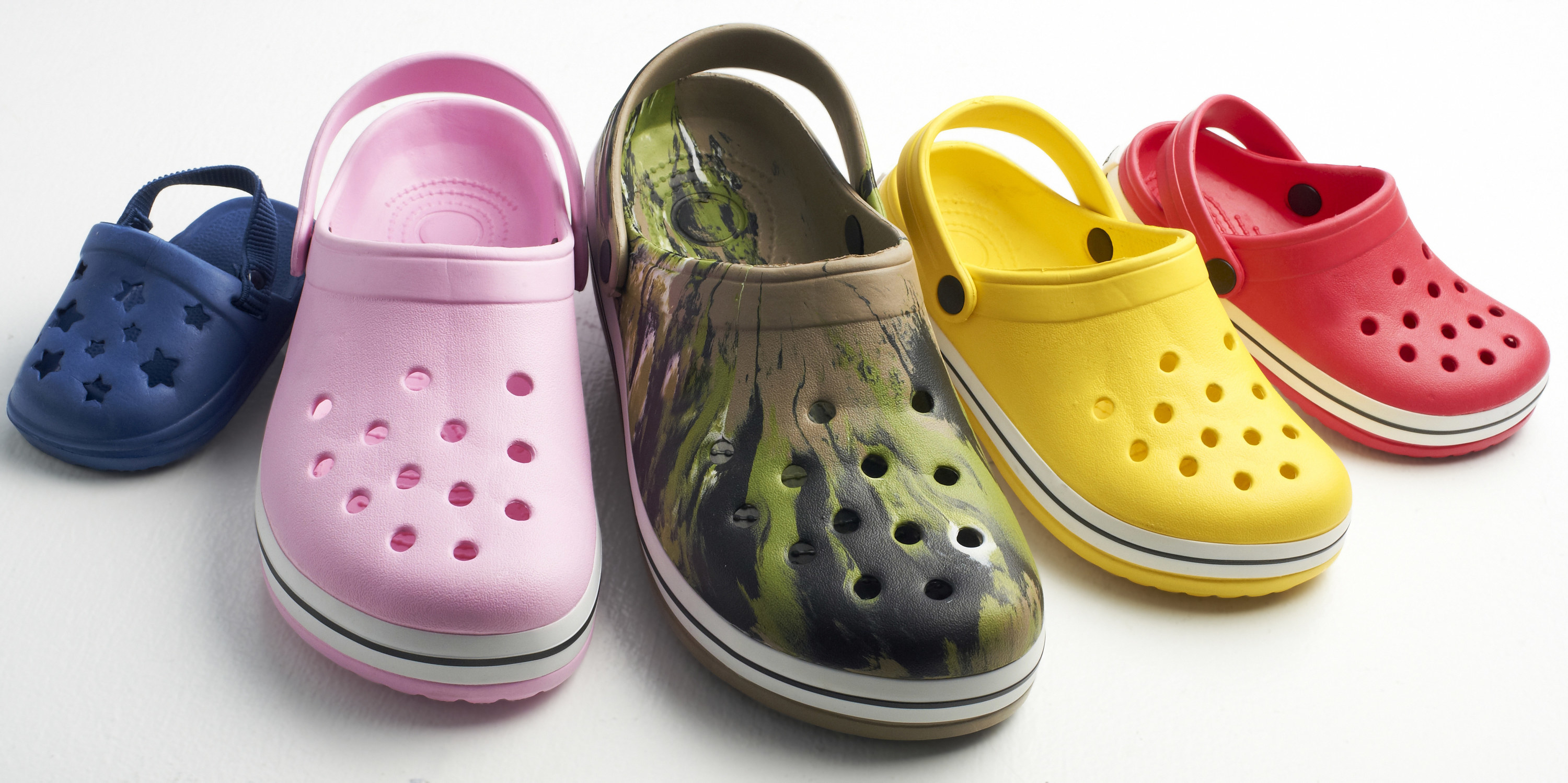 A bunch of Crocs in different colors and designs 