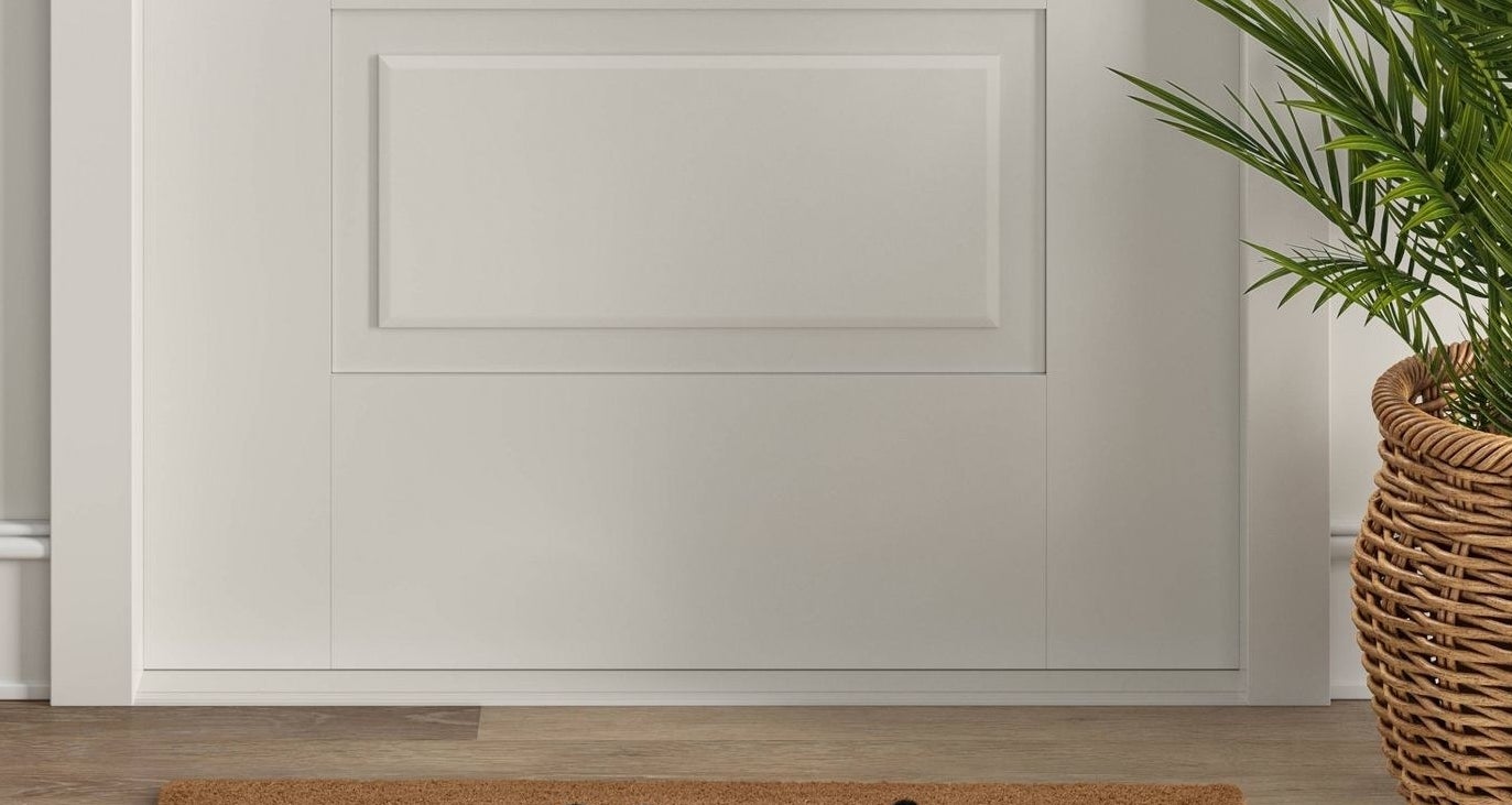 Tan welcome mat with black typography and design