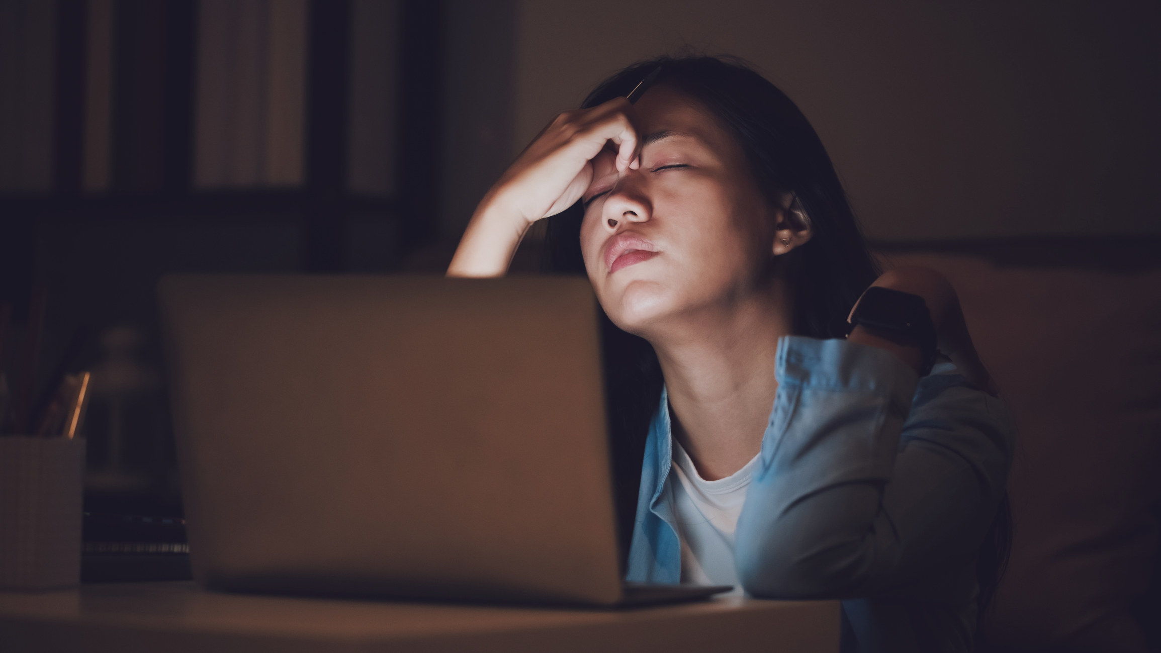 Woman sitting tiredly behind her computer