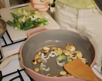 Model cooking veggies in Always pan