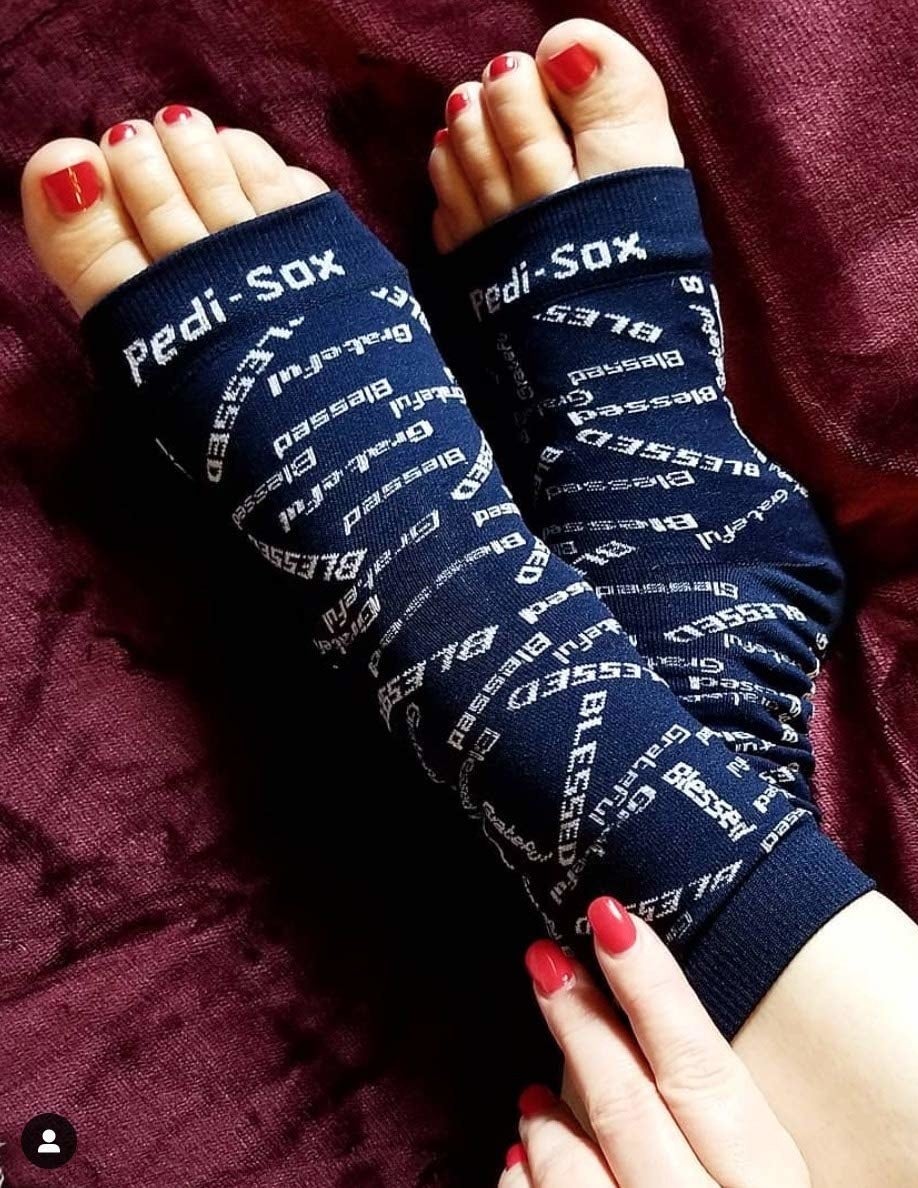 a model wearing the black socks which say "blessed"