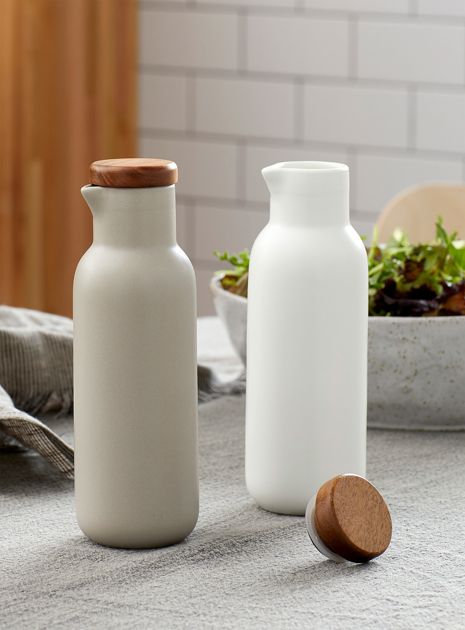 A pair of matte porcelain oil and vinegar cruets on a kitchen counter