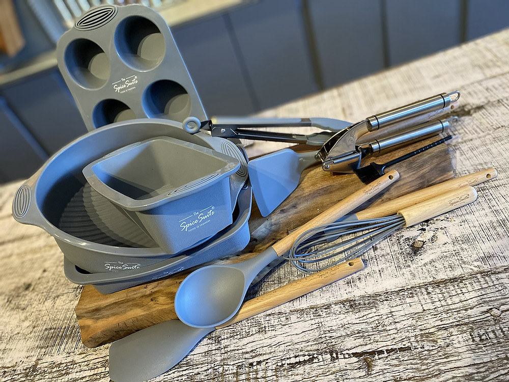 the four silicone bakeware, utensils with wood handles and silicone tops, and the garlic press