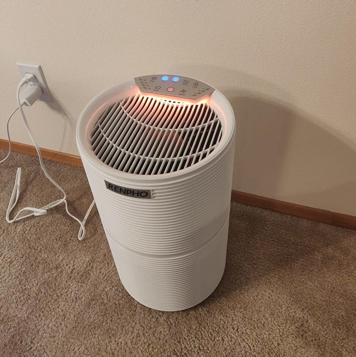 reviewer image of the white renpho air purifier sitting on carpet