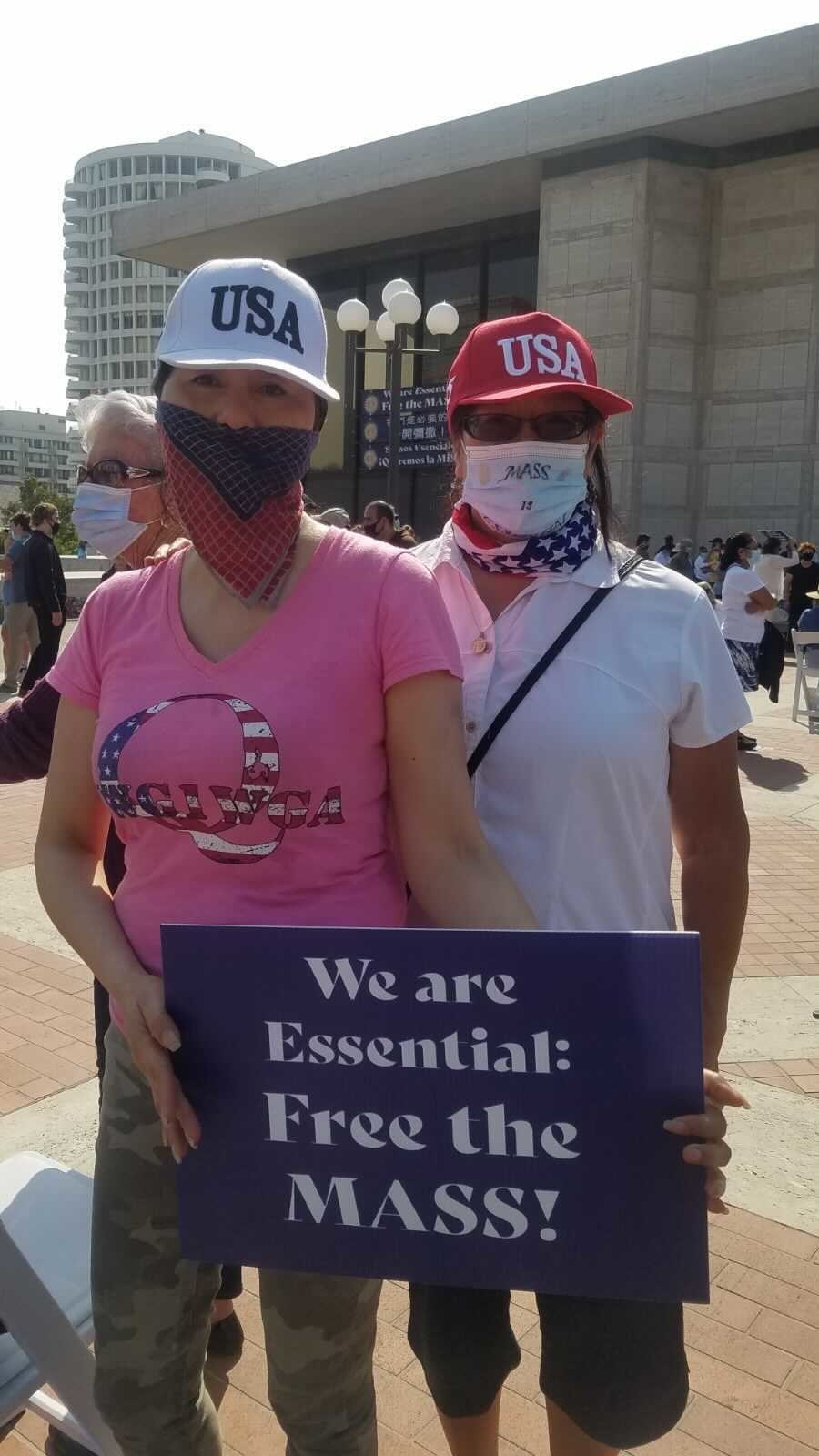 A sign says &quot;we are essential: free the mass&quot;