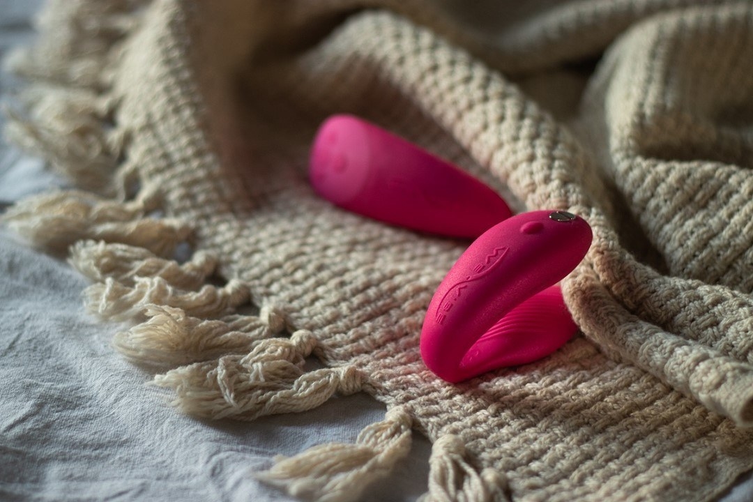 The dual vibrator on a blanket next to its remote 