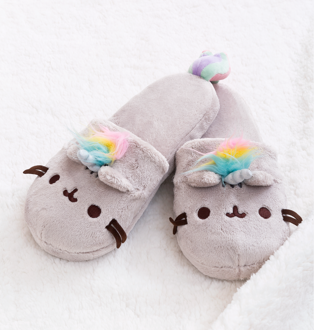 the gray slippers with a Pusheen face, whiskers, horn, and rainbow mane and tail