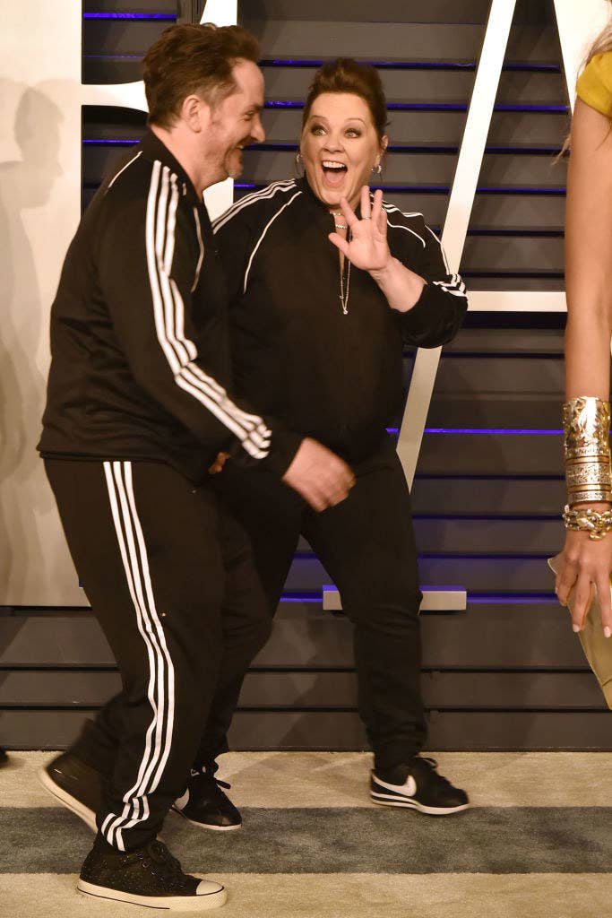 Melissa waves at someone as she and Ben walk the red carpet at the 2019 Vanity Fair Oscar Party