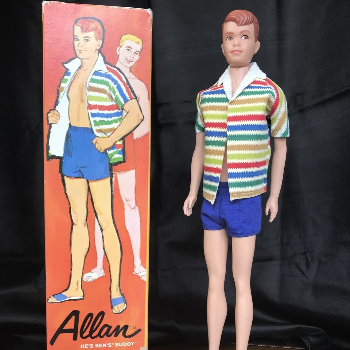 An Allan doll out his box wearing a blue swimsuit and stripped towel shirt