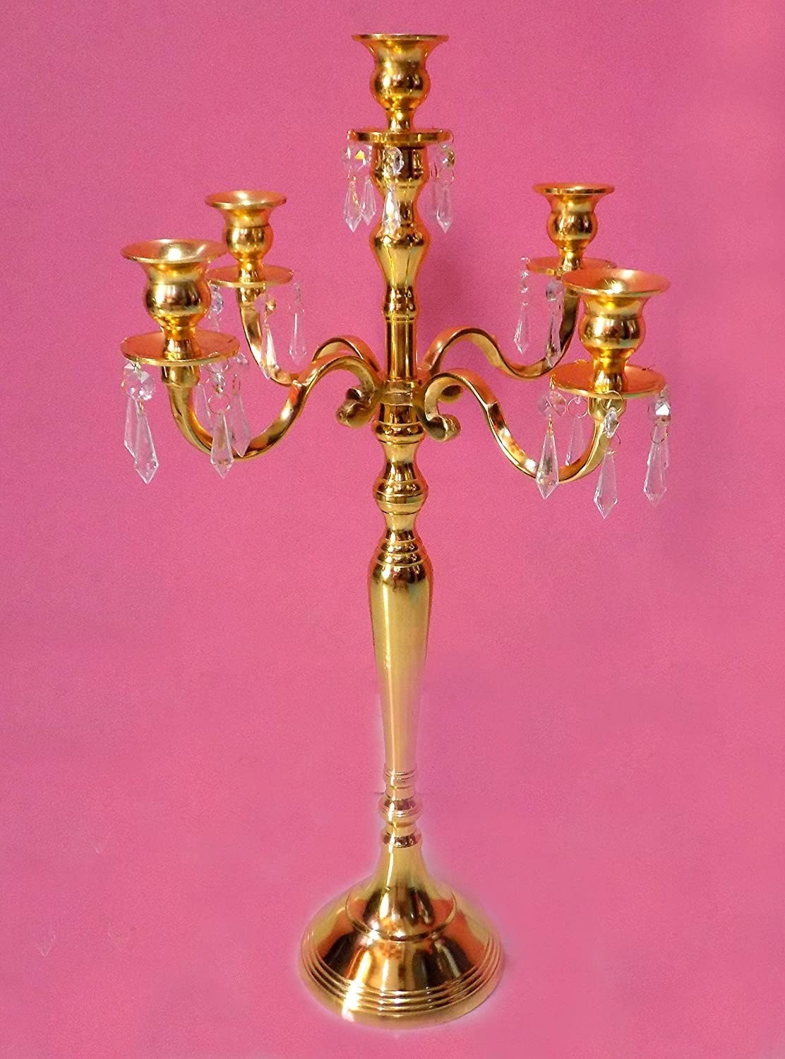 A golden candelabra against a pink background