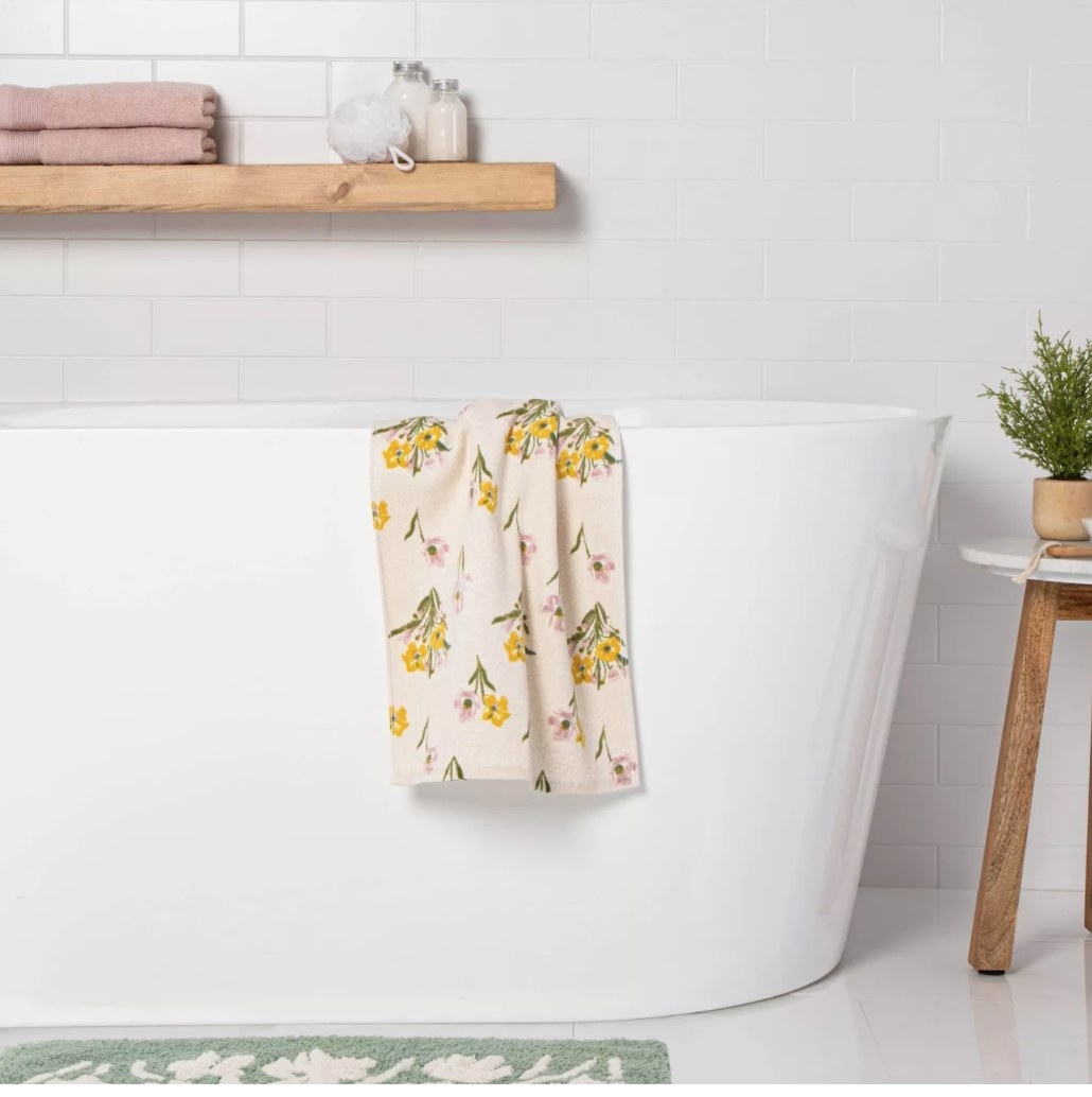 The hand towel draped over a bath tub 