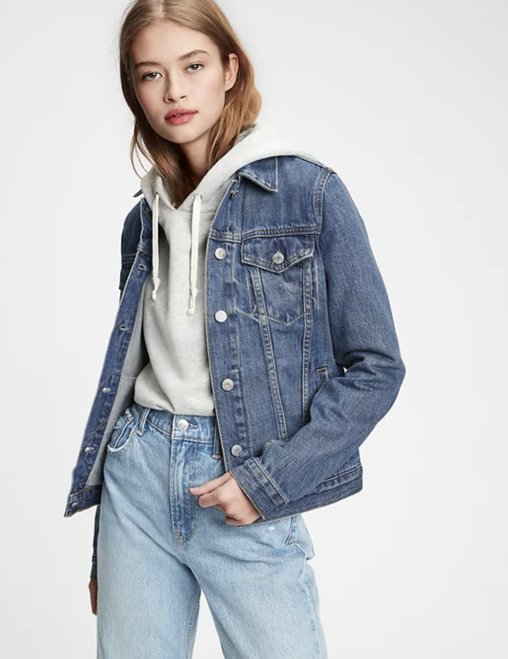 person wearing the denim jacket over a hoodie