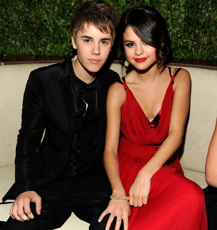 Selena sits next to Justin Bieber at an event