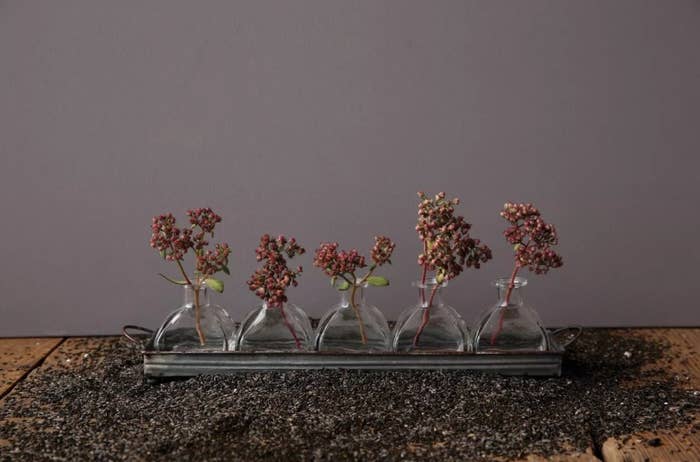 The vases in an iron tray on a bed of pebbles