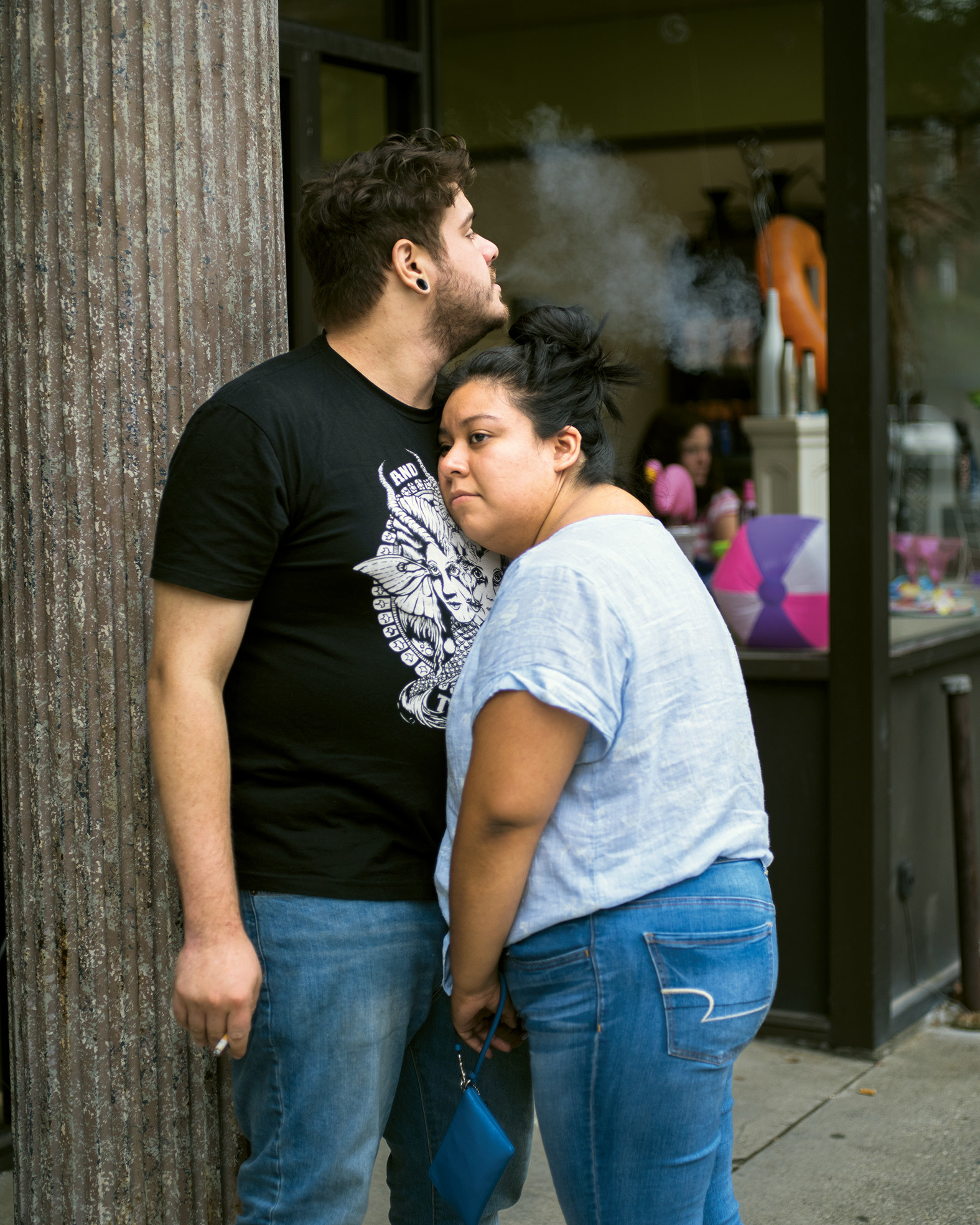 Two people embrace while smoking cigarettes