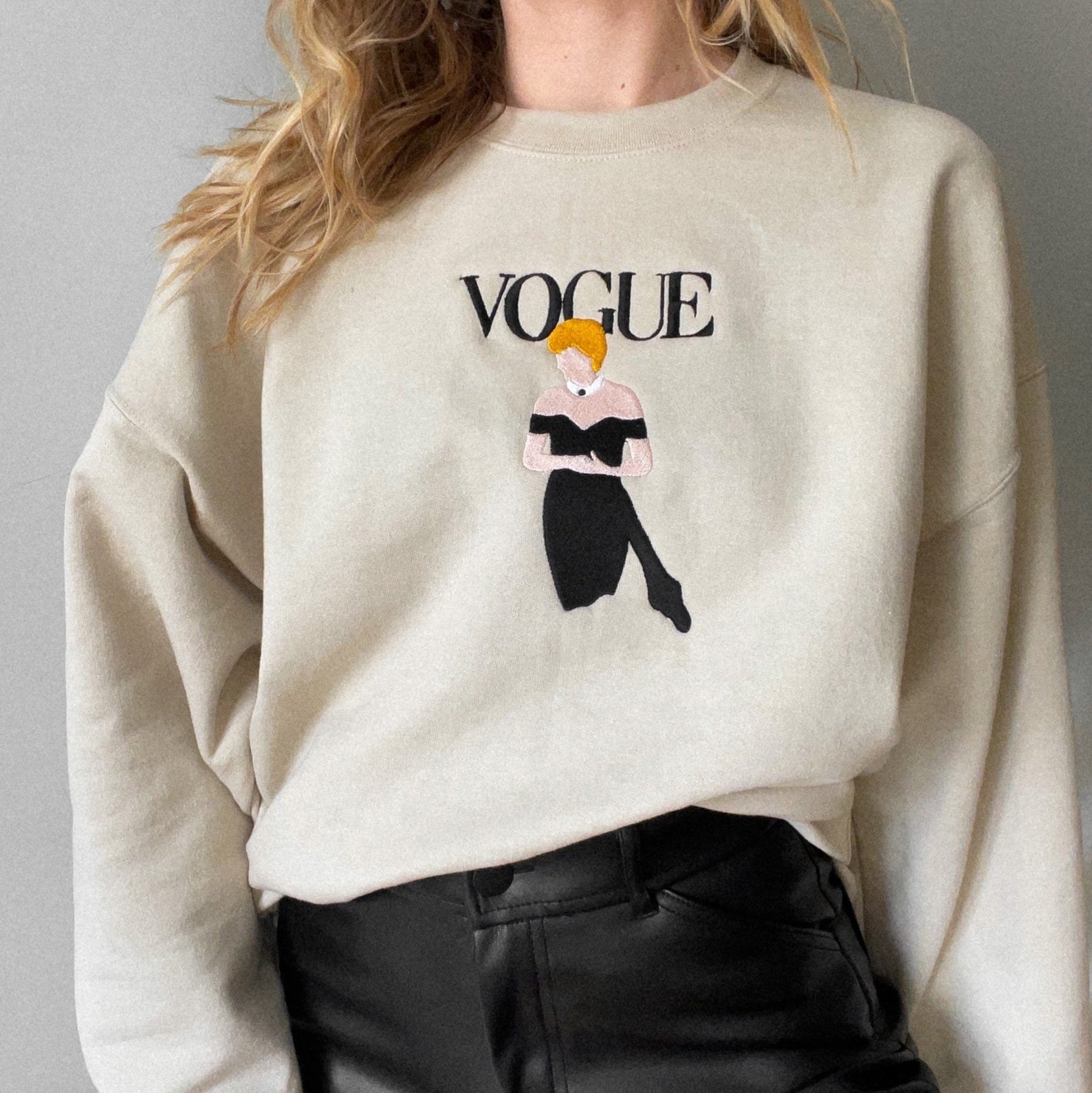 a tan sweatshirt with &quot;vogue&quot; embroidered on it and an image of princess diana in a black cocktail dress