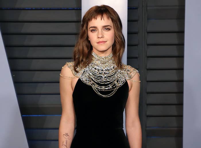 Emma Watson in a sleeveless outfit, long hair, and baby bangs