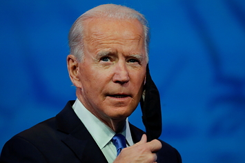 President Joe Biden taking off his face mask before giving a speech