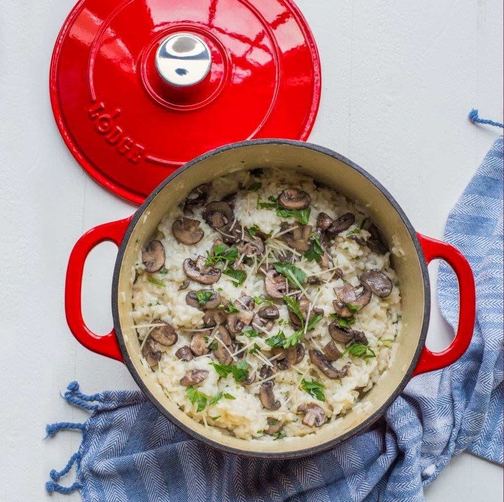 a red dutch oven holding mushroom risotto 