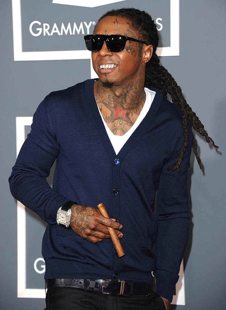 Lil Wayne holding an unlit cigar on the red carpet