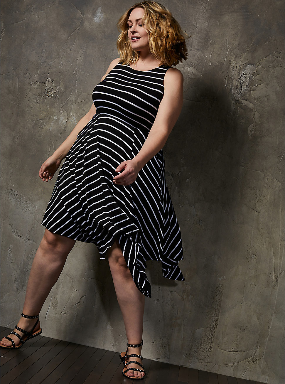 a model wearing the black dress with white stripes with sandals