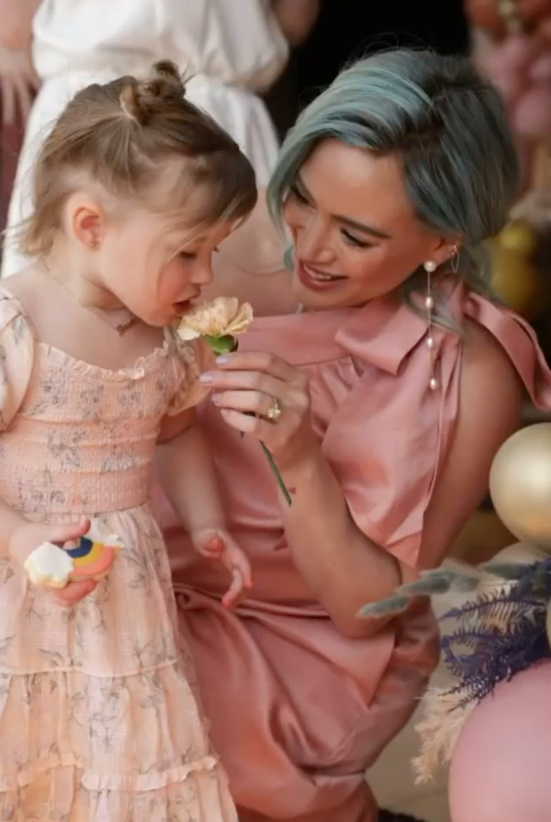 Hilary Duff and her daughter look at a flower at her baby shower