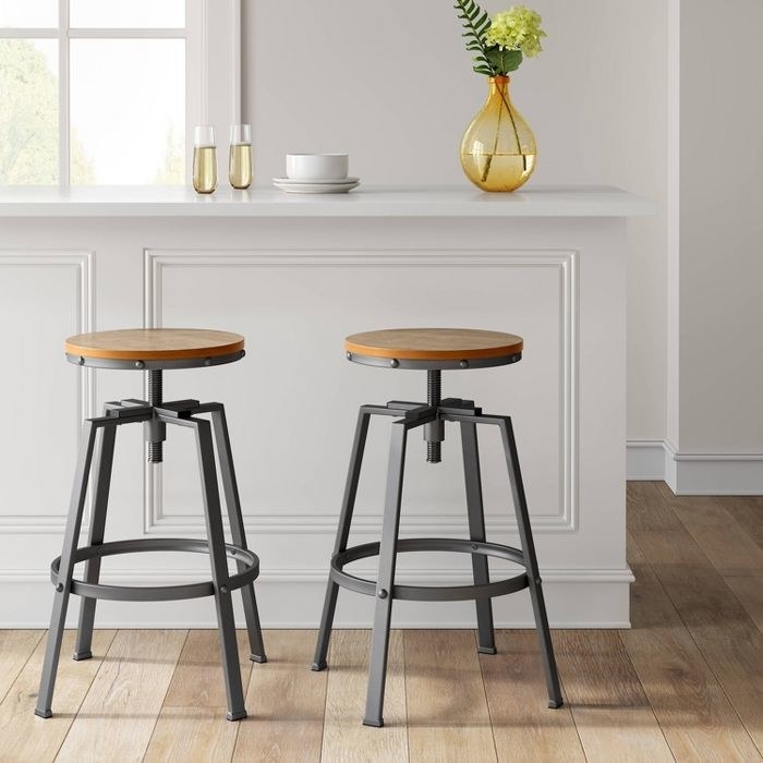 wood and metal framed industrial-design barstools next to a counter