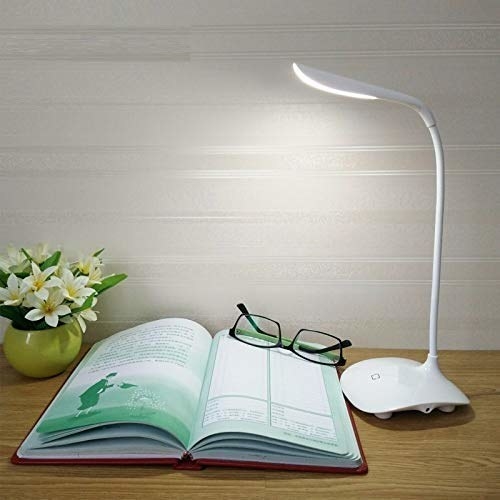 A white LED lamp next to a book 