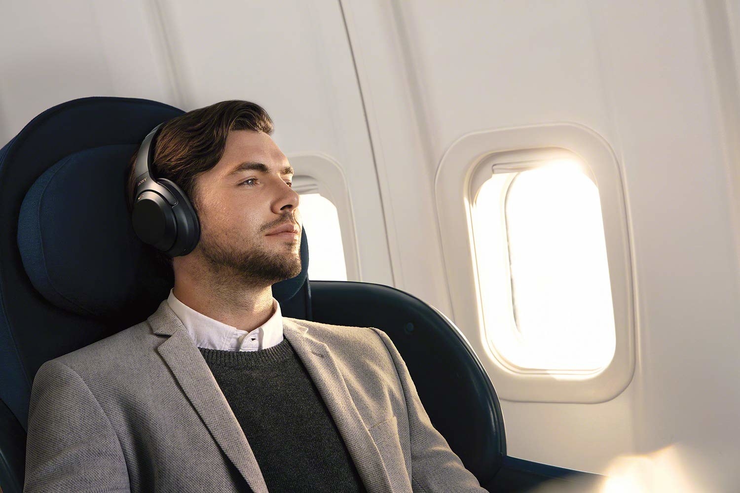 A man wearing the Sony noise-cancellation headphones on a plane 