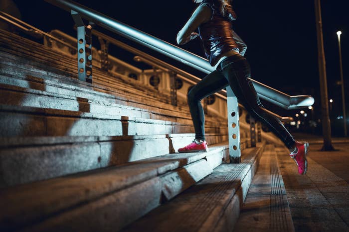 A woman running up steps at night