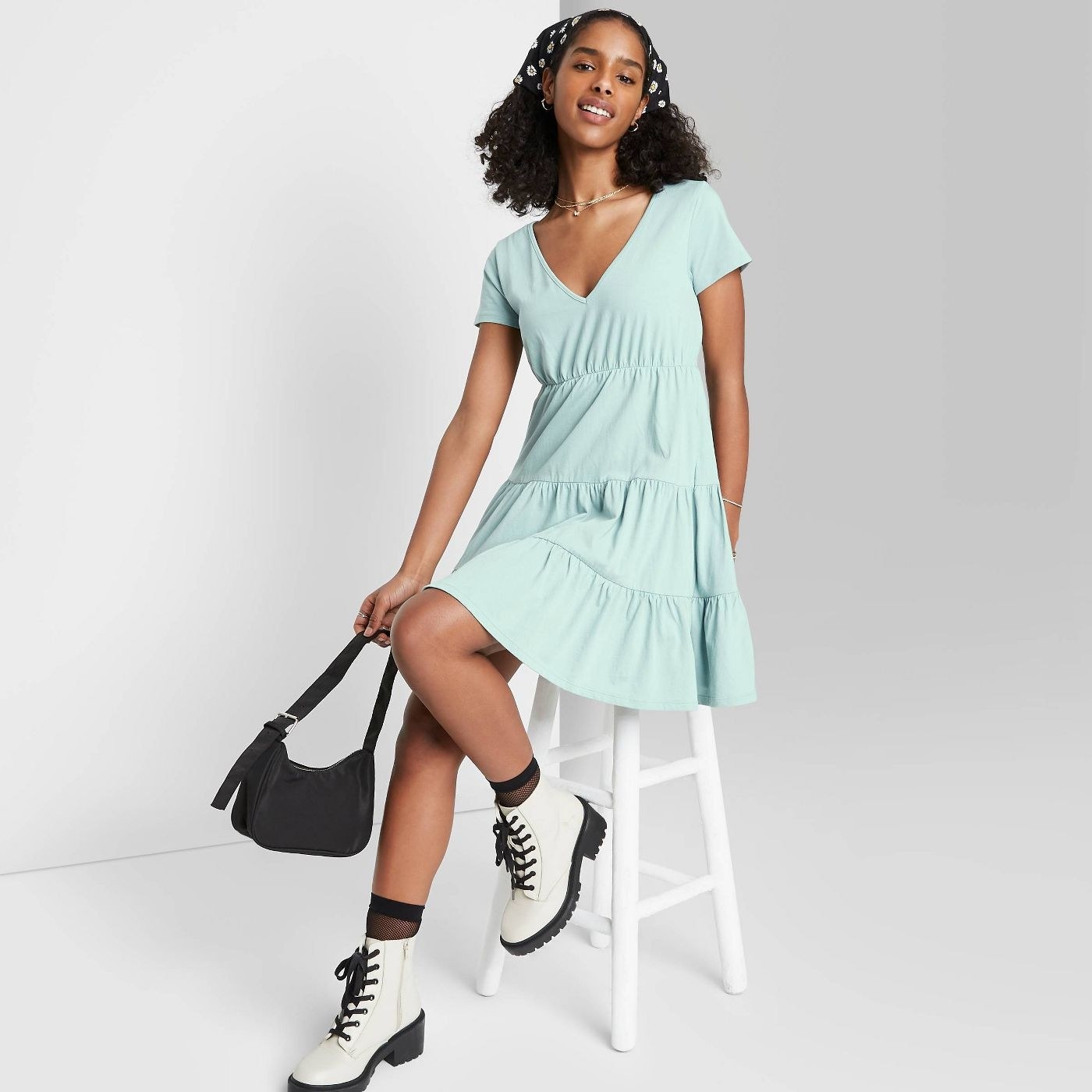 Model wearing light blue v-neck dress with tiered silhouette 