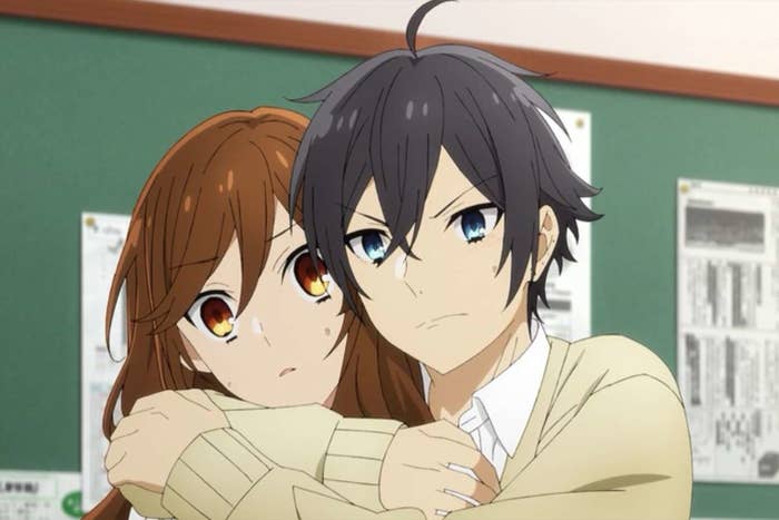 an animated teen male and female hug in a classroom