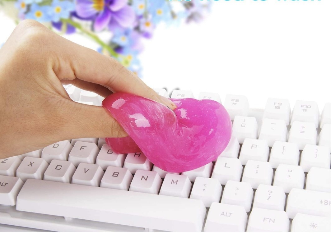 A pink cleaning gel cleaning out a keyboard