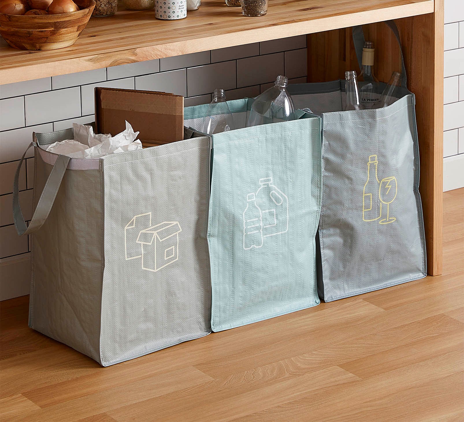 Three large plastic bags with different types of recycled materials in each