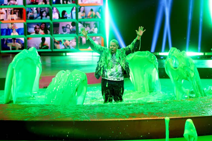 Host Kenan Thompson stands in a pool of slime