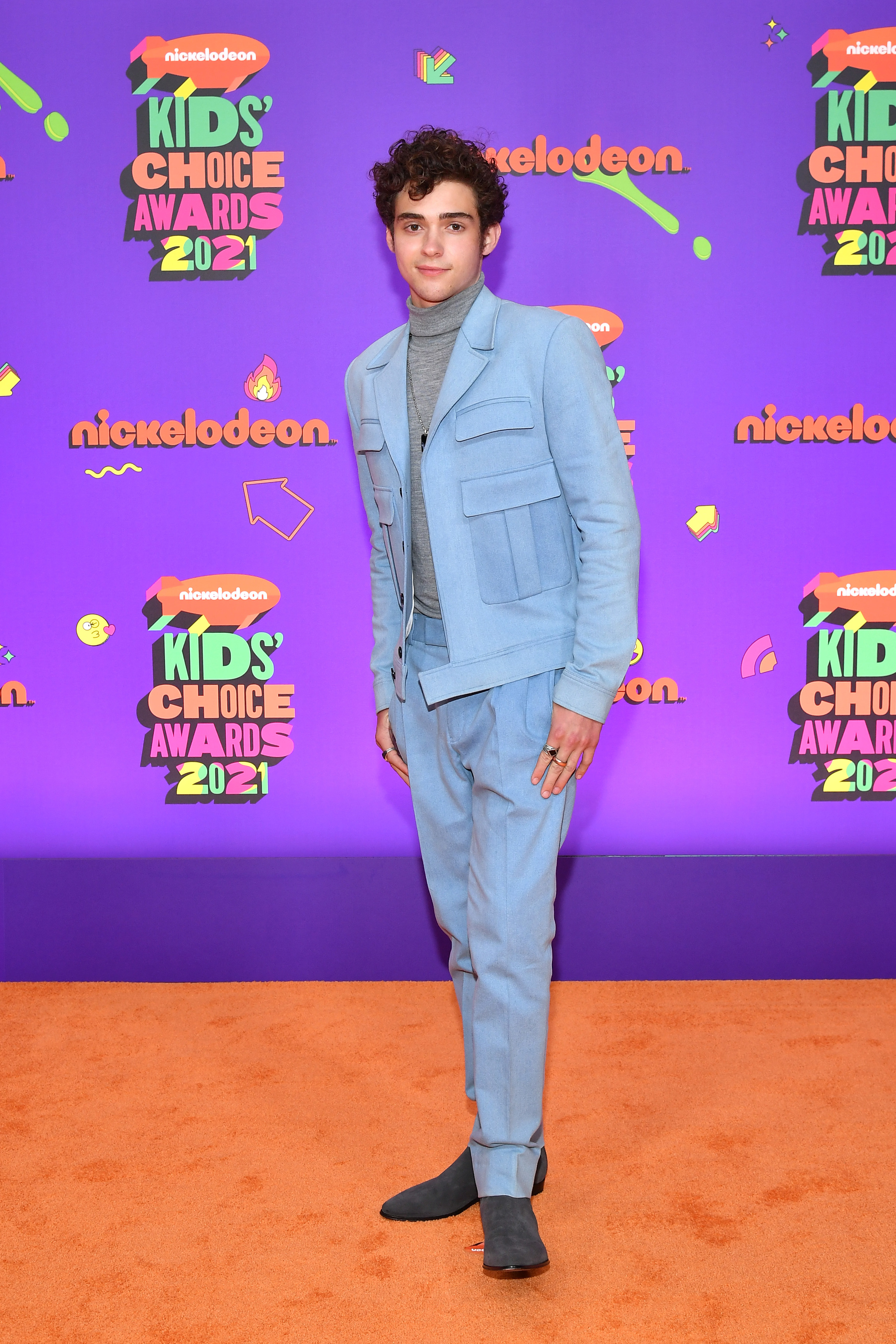 Joshua in a powder blue suit pants with a modern jacket with large pockets