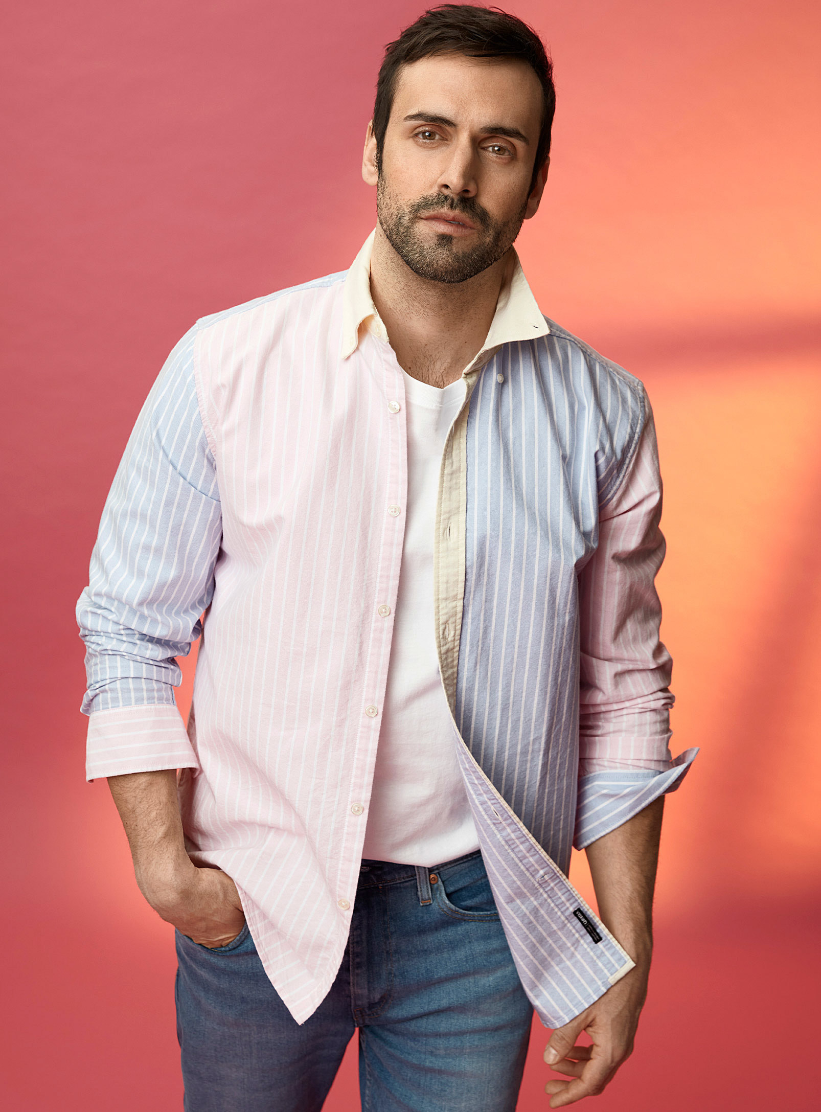 A person wearing a button up shirt over a T-shirt and jeans