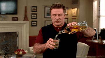 Alec Baldwin pouring himself scotch.