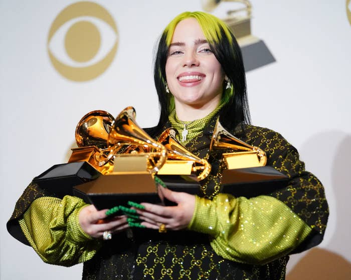 Billie holding multiple Grammys backstage