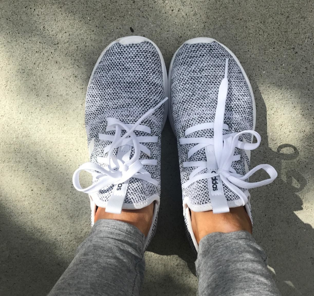 reviewer wearing black and white adidas running shoes with white shoelaces