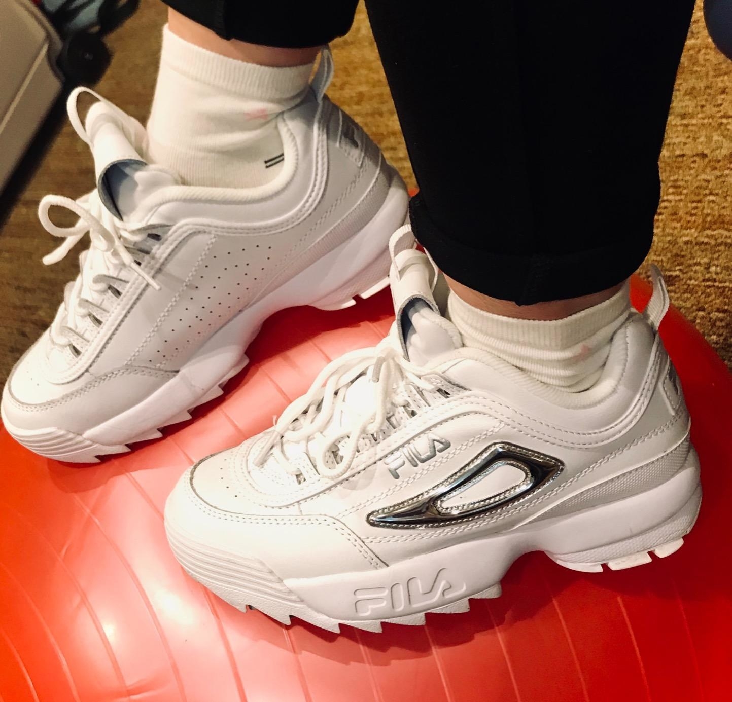 reviewer wearing chunky white fila sneakers