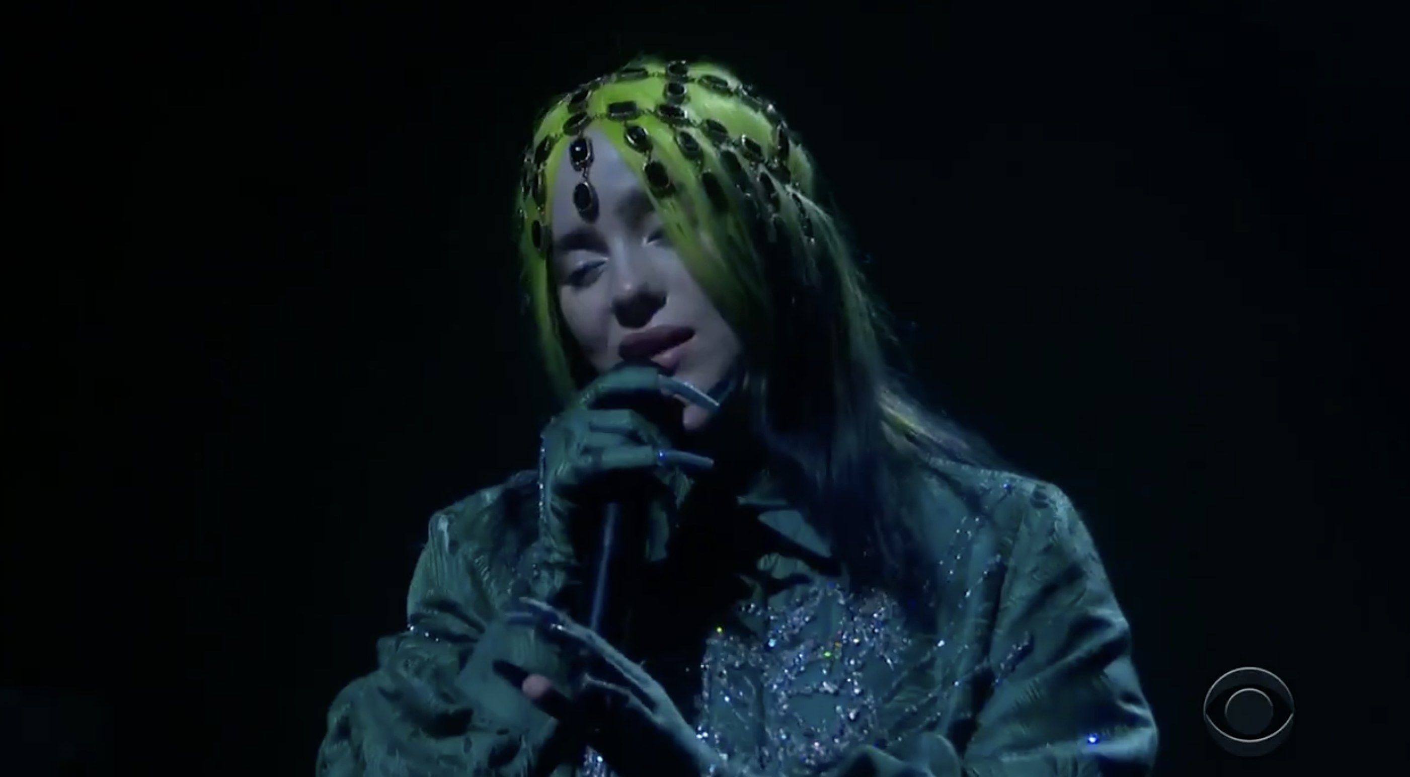 Billie wears a sparkling green jacket and jeweled head piece