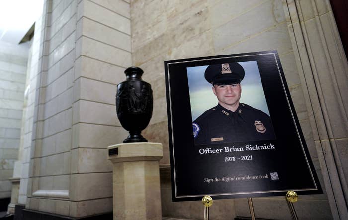 A large photo sits in the Capitol Rotunda and shows Officer Sicknick in uniform and lists his name and years of birth and death (1978 and 2021)