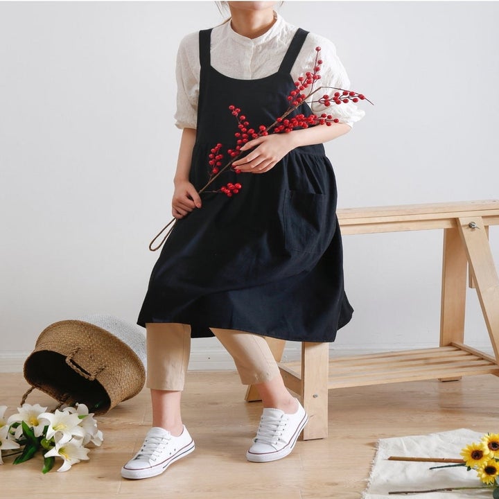 navy apron that can be worn as a dress over a shirt 