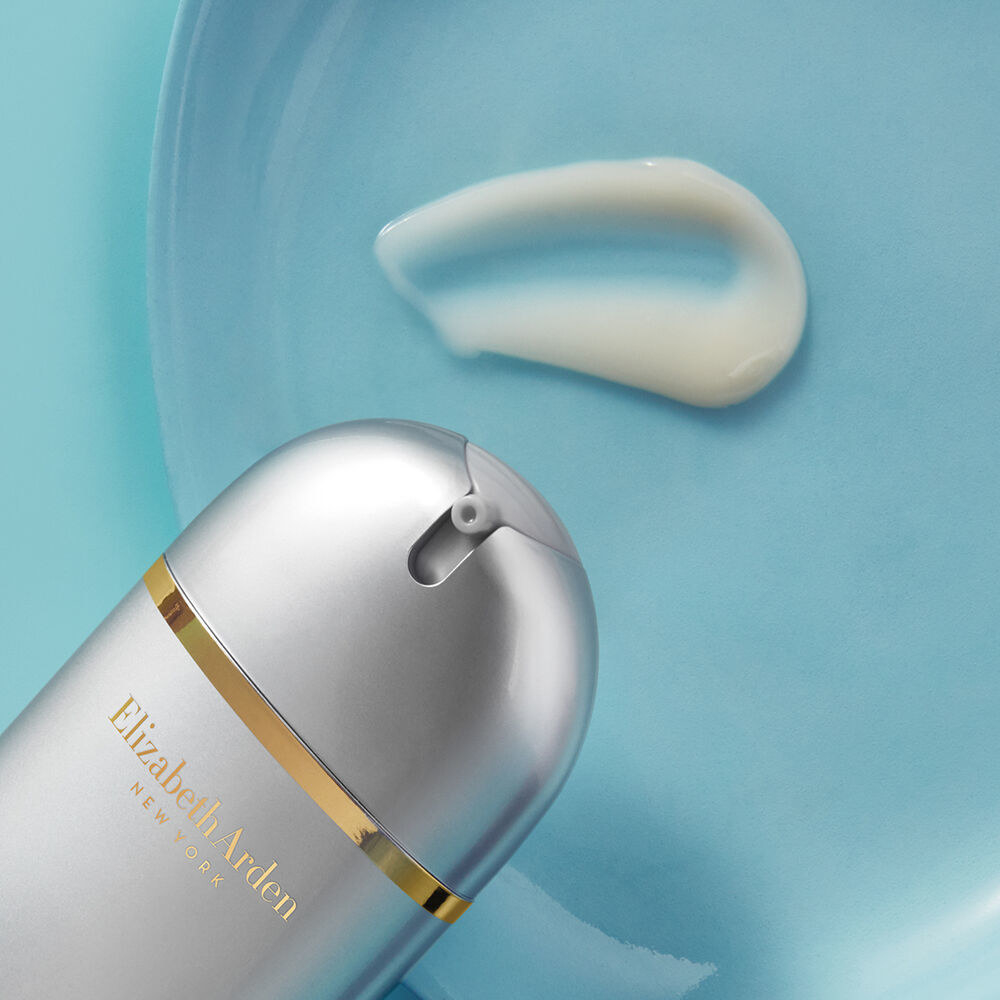 the Skin Renewal Booster in a silver and gold bottle squirting out white formula