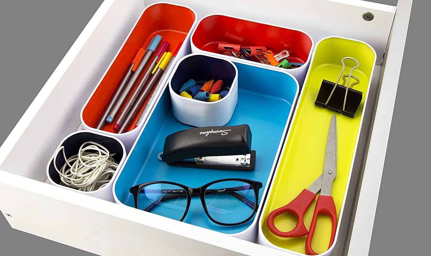 A flatlay of the Interchangeable organizers filled with office supplies