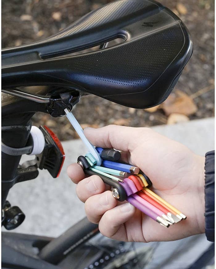 A person using the multi-purpose tool on their bike seat 